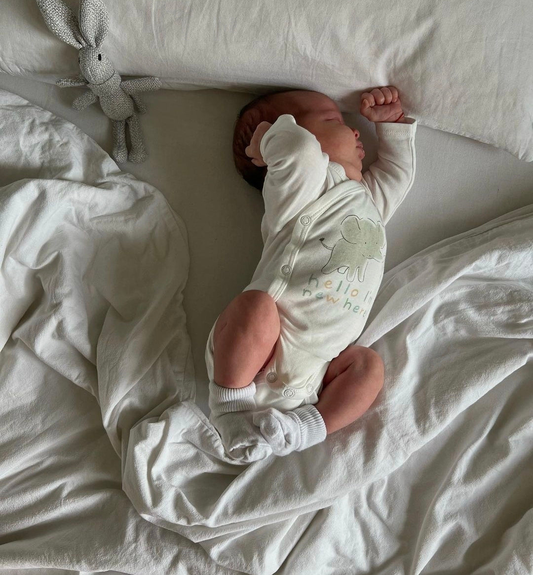 bébé qui est endormi dans le lit de ses parents.