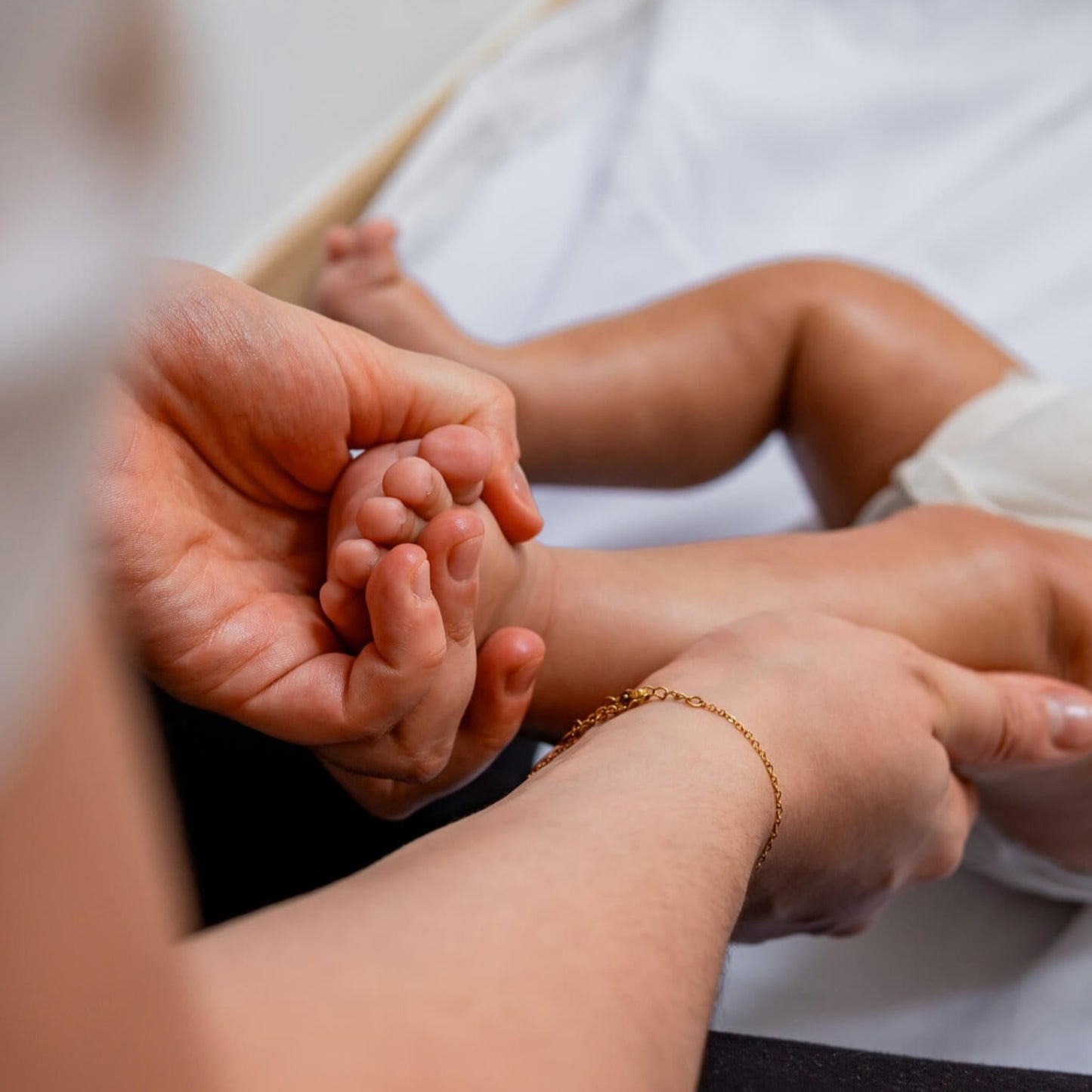 Maman masse les jambes de son bébé.